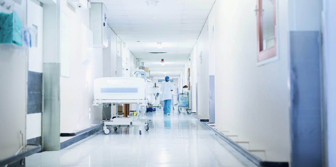 844400552 Rearview shot of a surgeon walking down a hospital corridor
