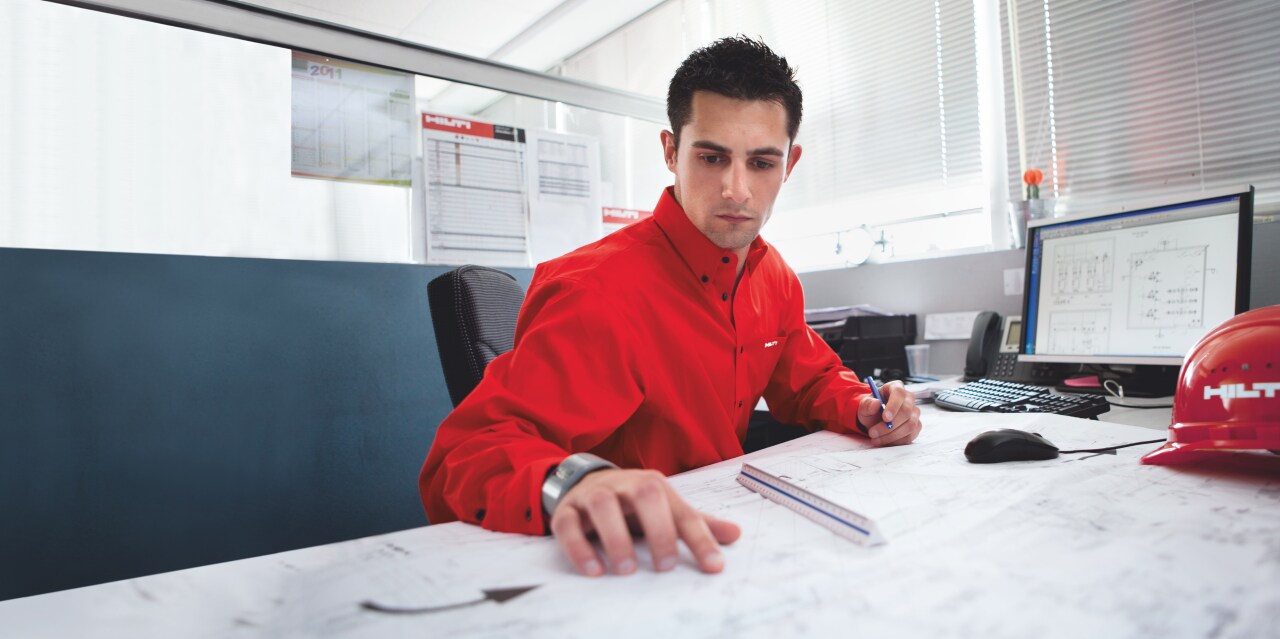 Photo of a Hilti Engineer at his desk, carrying out an engineering judgement for a customer.