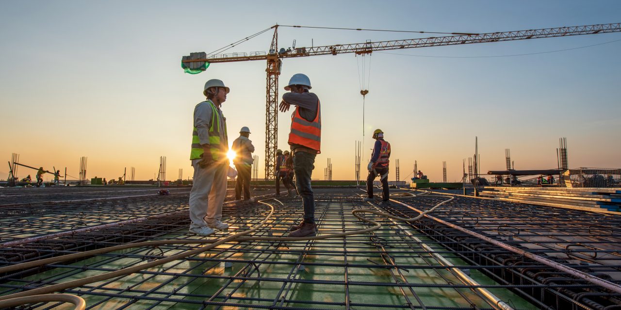 Construction engineer working at construction site during sunset time